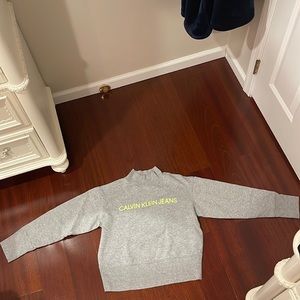 Turtle neck long sleeve. Gray sweater with green Calvin Klein Jeans label.